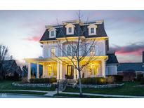 Charming two-story home boasts a welcoming porch and manicured landscaping, creating a picturesque curb appeal at 12813 Chapel Square St, Carmel, IN 46032
