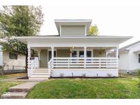 Charming home with a welcoming front porch, green siding, white trim, and well-manicured lawn at 1515 Dawson St, Indianapolis, IN 46203