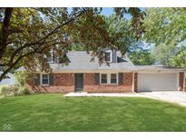 Charming brick home features a well-maintained lawn and a two-car garage at 1528 N Dukane Way, Indianapolis, IN 46214