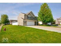 Charming two-story home with a well-manicured lawn, an attached garage, and appealing curb appeal at 2009 Quarter Path Rd, Cicero, IN 46034