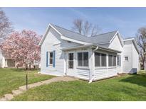 Charming single Gathering home with white siding, gray roof, and colorful landscaping at 218 Illinois St, Shirley, IN 47384