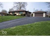 Charming single story home with brick facade, manicured lawn and separate two car garage at 2448 Depauw Rd, Indianapolis, IN 46227