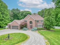 Traditional brick home featuring an oversized front lawn, circular driveway, and mature trees at 4743 Little Hurricane Rd, Martinsville, IN 46151