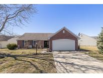 Charming red brick single-story home with attached two car garage and a well-manicured lawn at 546 Treyburn Lakes Way, Indianapolis, IN 46239