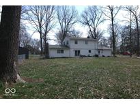 View of the home's backyard, with ample lawn space and mature trees at 7546 Lindenwood Dr, Indianapolis, IN 46227