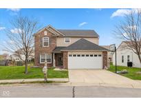 Charming two-story home featuring a brick facade, attached two car garage and well maintained front yard at 1167 Dark Star Ct, New Whiteland, IN 46184