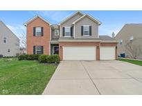Charming two-story home with brick and siding, a well-manicured lawn, and an attached three car garage at 13931 Keams Dr, Fishers, IN 46038
