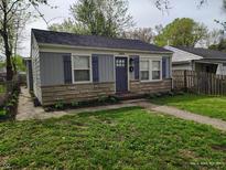 Charming one-story home with stone accents, blue shutters, and a well-maintained lawn at 1806 Asbury St, Indianapolis, IN 46203