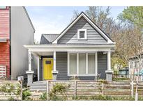 Charming home featuring a gray exterior with a bright yellow front door at 2006 Lexington Ave, Indianapolis, IN 46203