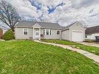 Charming single-story home with gray siding, well-maintained lawn, and a detached one-car garage at 2920 Lincoln St, Anderson, IN 46016