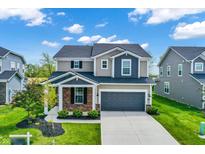 Charming two-story home featuring a well-maintained lawn, gray garage door, and a welcoming brick-accented porch at 4941 Oak Hill Dr, Lebanon, IN 46052