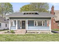 Inviting home with a covered porch, classic architecture, and a well-manicured lawn at 5028 Graceland Ave, Indianapolis, IN 46208