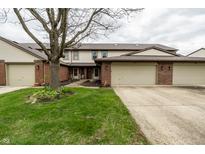 Traditional townhome with brick accents, attached garages, and a well-maintained lawn at 5367 Cotton Bay W Dr, Indianapolis, IN 46254