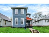 Charming two-story home featuring blue siding and a welcoming front porch on a well-maintained lawn at 725 N Sheffield Ave, Indianapolis, IN 46222