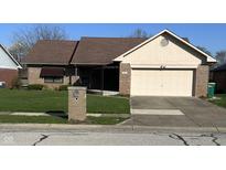 Charming brick home featuring a covered front porch and an attached two-car garage at 1010 Pamela Dr, Plainfield, IN 46168
