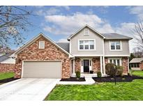 Charming brick and siding two-story home with a well-manicured lawn and attached two-car garage at 10234 Leeward Blvd, Indianapolis, IN 46256