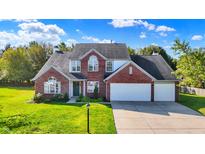 Charming brick home featuring a three-car garage and a well-manicured lawn at 10401 Monarch Ct, Noblesville, IN 46060