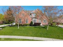 Beautiful two-story brick home featuring a well-manicured lawn and lovely landscaping at 10611 Proposal Pointe Way, Fishers, IN 46040