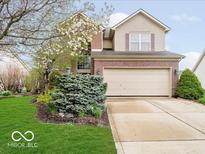 Charming two-story home with a brick facade, two car garage, and a well-manicured lawn at 13921 Leatherwood Dr, Carmel, IN 46033