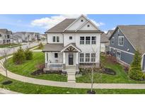 Beautiful two-story home boasting a charming front porch, manicured lawn, and modern architectural design at 15591 Heatherbank Dr, Westfield, IN 46074