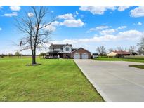 Expansive home featuring a long driveway, green lawn, and a two-car garage at 1687 E 600 N, Whiteland, IN 46184
