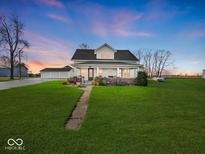 Charming two-story home with lush lawn and inviting front porch beneath a colorful evening sky at 2083 E 750 S, Flat Rock, IN 47234