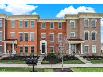 Beautiful brick townhomes feature manicured lawns, landscaping, and inviting front porches for curb appeal at 2627 Congress St, Carmel, IN 46032