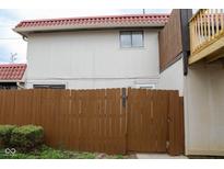 Two-story home displaying a combination of brown fences and a tan exterior with a red-tiled roof at 2862 Punto Alto Ct, Indianapolis, IN 46227