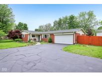 Charming brick ranch home with an attached two-car garage and beautiful landscaping at 2910 S Sheridan Ave, Indianapolis, IN 46203
