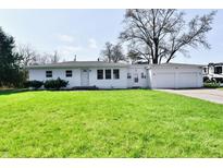 Charming single-story home with a well-manicured lawn and an attached two car garage at 3015 E Sumner Ave, Indianapolis, IN 46237
