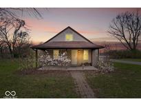 Charming home with a covered porch, complemented by lovely landscaping and a brick pathway at 3070 N Layman Ave, Indianapolis, IN 46218