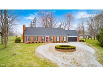 Charming single-story brick home featuring a circular driveway, attached garage, and well-maintained landscaping at 345 E Main St, Jamestown, IN 46147
