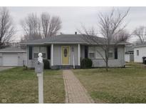 Charming one-story home with a brick walkway and a bright yellow front door, complemented by a tidy front yard at 406 W Jackson St, Alexandria, IN 46001