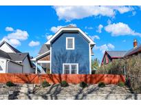 Charming blue two-story home with a vibrant orange fence and landscaped yard at 424 N Randolph St, Indianapolis, IN 46201