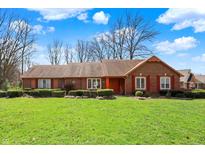 Charming brick home features a well-manicured lawn, tidy landscaping, and traditional shutters at 4263 W Fox Ridge Ave, Greenwood, IN 46143