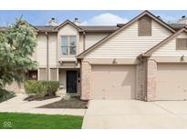 Inviting townhome featuring an attached garage, neutral siding and nicely manicured landscaping at 7208 Long Boat Dr, Indianapolis, IN 46250