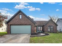 Charming single-story brick home featuring an attached garage and well-maintained landscaping at 8807 Wintergreen Way, Indianapolis, IN 46256