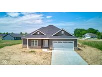 Charming single-Gathering home features gray siding, a concrete driveway, and a two-car garage at 9182 Mulligan Ct, Elwood, IN 46036