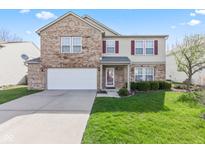 Inviting two-story home with a well-manicured lawn, attached garage, and brick facade, perfect for curb appeal at 10221 Tournon Dr, Fishers, IN 46037