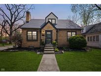 Charming brick home featuring a well-manicured lawn, complemented by elegant landscaping and a welcoming entrance at 1025 E 60Th St, Indianapolis, IN 46220