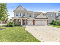 Charming two-story home with a three-car garage, manicured lawn, and inviting front porch at 11003 Liberation Trce, Noblesville, IN 46060