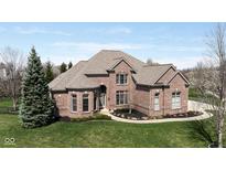 Stunning brick home featuring a manicured lawn and beautiful landscaping at 13214 Mink Ln, Carmel, IN 46074