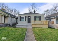 Charming single-story home featuring a neat front yard, gray siding, a small porch, and black shutters at 1331 W 33Rd St, Indianapolis, IN 46208
