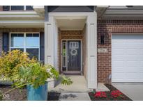 Charming front door with decorative wreath and sidelights, accented by brick and fresh landscaping at 2736 Victory Dr, Columbus, IN 47203