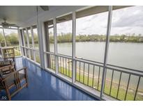 Enclosed sunroom with wood furnishings features a waterfront view and plenty of natural light at 3004 Lake Shore Dr # E, Indianapolis, IN 46205