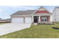 Charming brick home with a three-car garage, red accents and manicured lawn in a suburban setting at 3601 S Meadows Ln, New Palestine, IN 46163