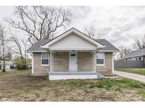 Charming stone home with a front porch and gray accents, offering a welcoming facade at 4945 Camden St, Indianapolis, IN 46227