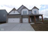 New two-story home featuring a brick facade, three-car garage, covered porch, and architectural roof details at 4960 Cinnabar Trl, Brownsburg, IN 46112