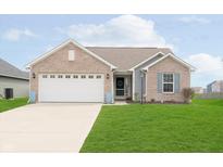 Well-maintained single-Gathering home with a two-car attached garage and manicured lawn at 6467 W Whispering N Way, Greenfield, IN 46140