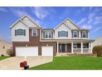 Inviting two-story home with a brick facade, two-car garage, and covered front porch at 7048 Millet Ln, Avon, IN 46123